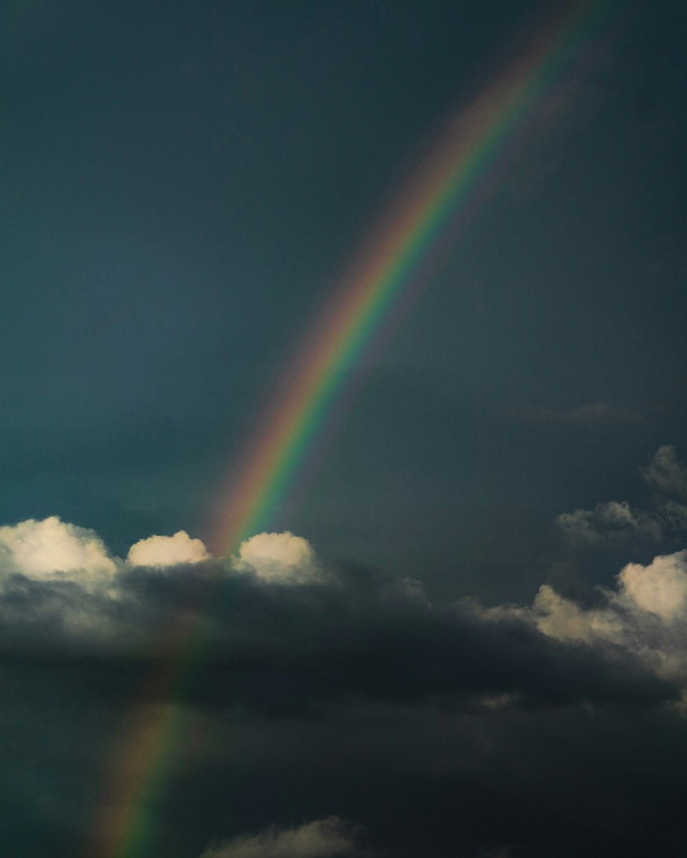 a rainbow in the sky with clouds in the background