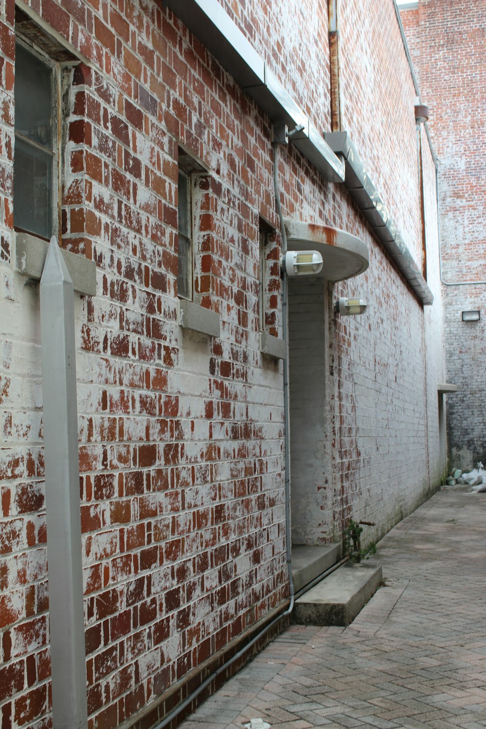 a brick building with two windows and a street light