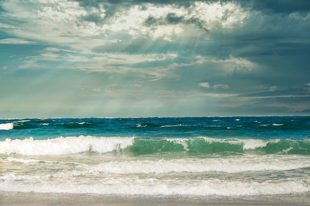 the sun shines through the clouds over the ocean