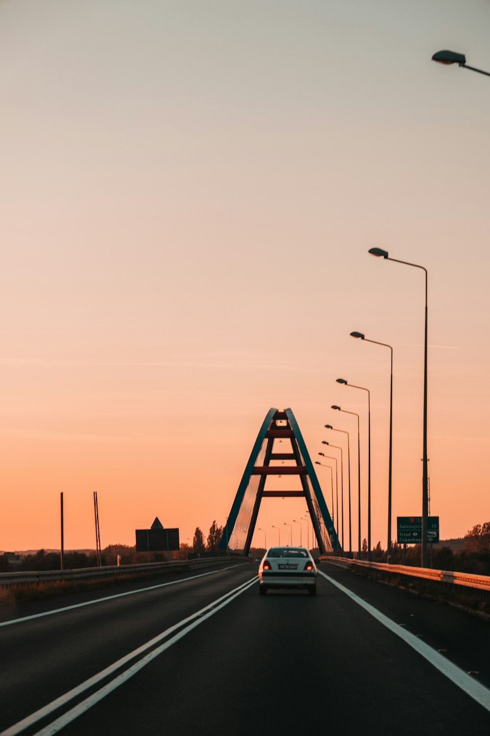 a car driving down a highway at sunset