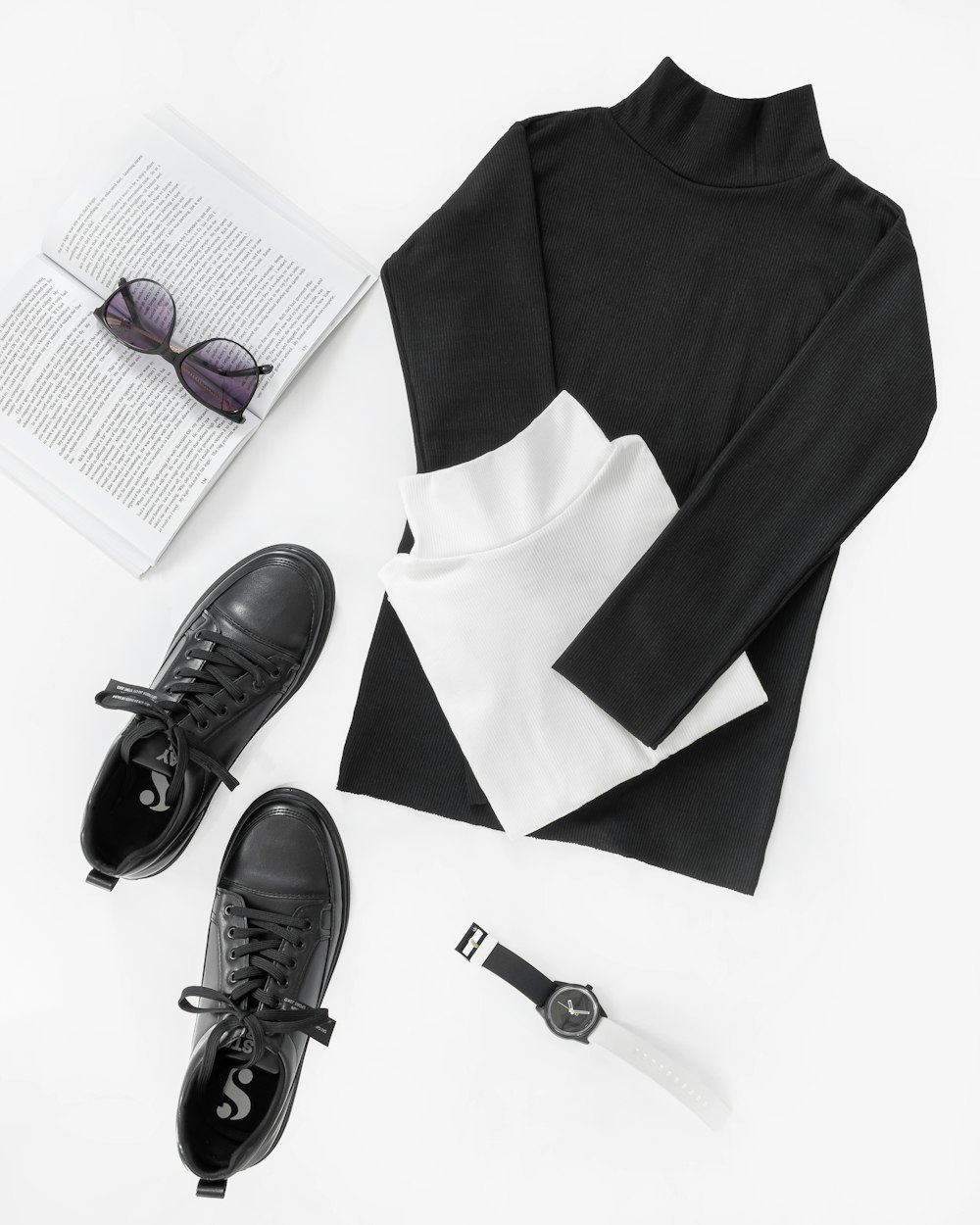 a pair of black shoes, a black sweater, and a pair of black sunglasses