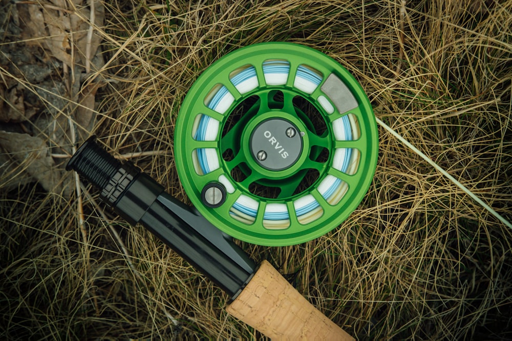 a green fly fishing reel and a fly rod