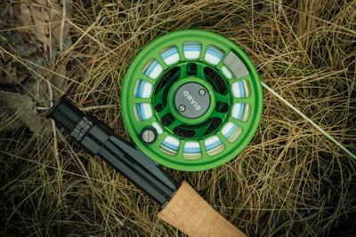 a green fly fishing reel and a fly rod