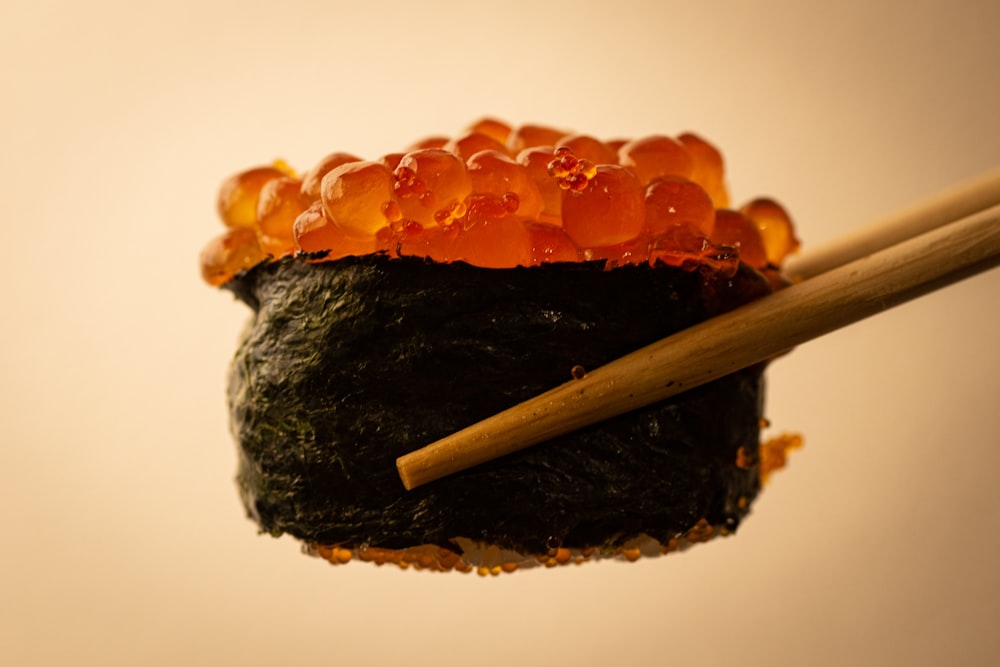 Gros plan d’un sushi avec des baguettes