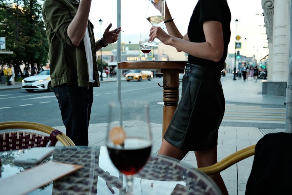 ワインを片手にテーブルに立つ男女