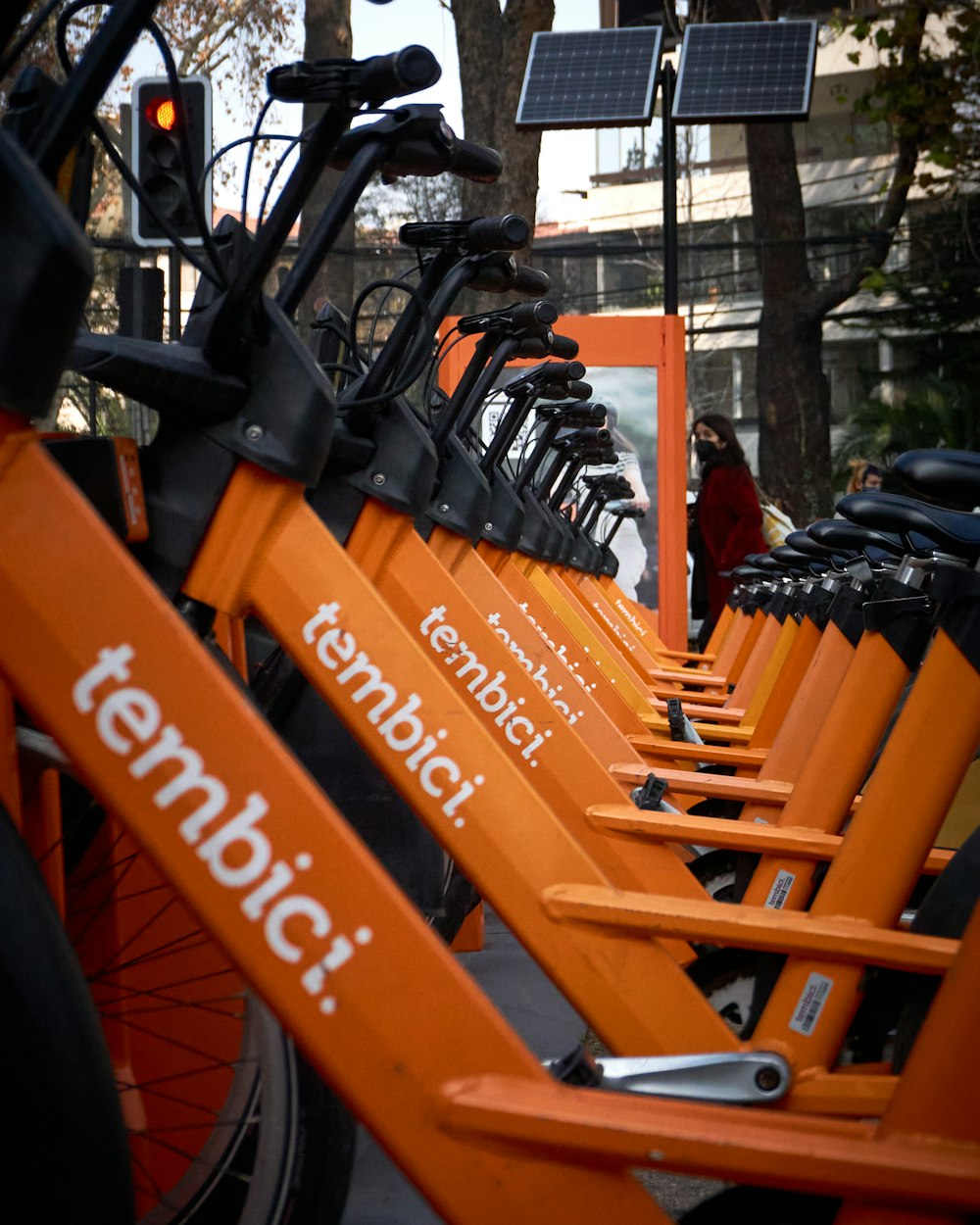 a row of orange bicycles parked next to each other