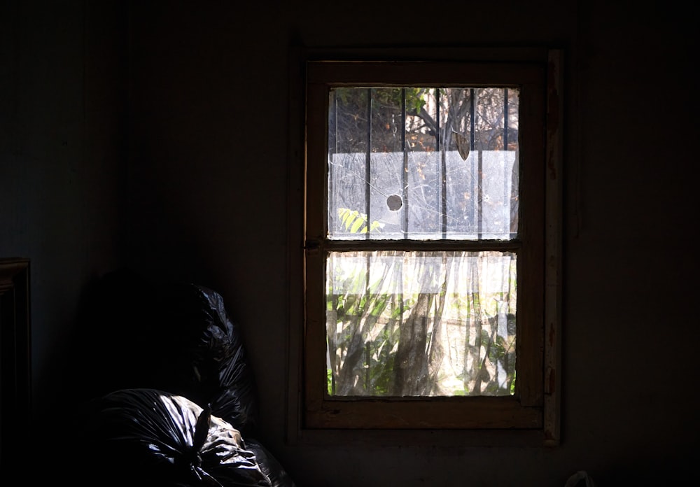 a dark room with a window and a blanket on the floor