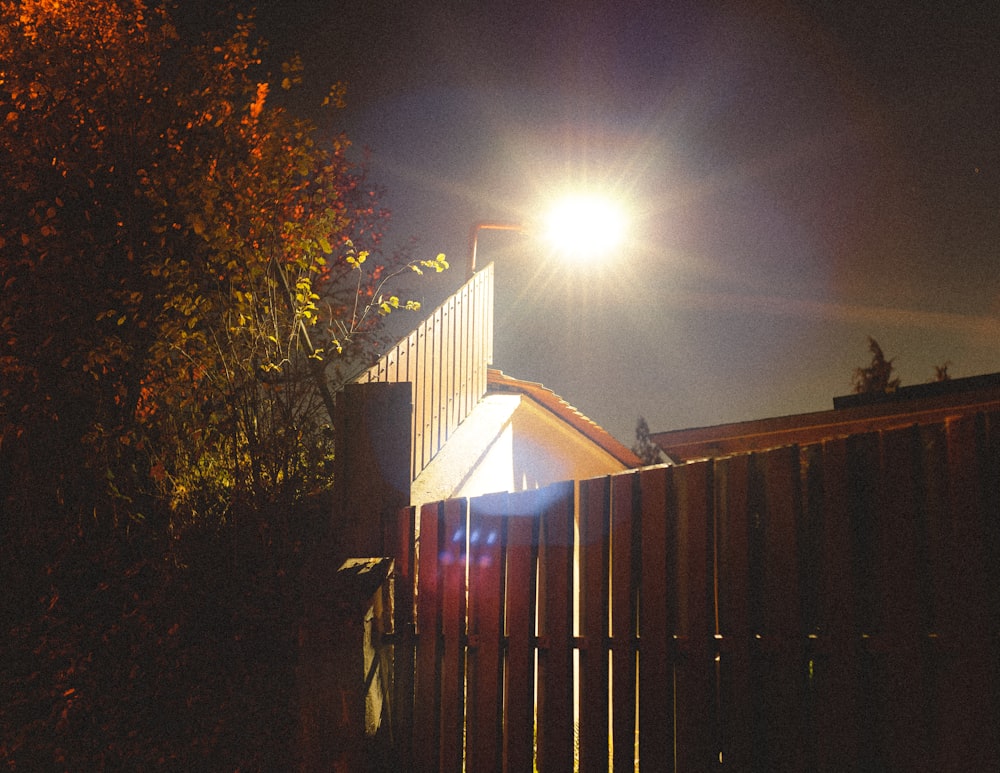 a street light shines brightly on a dark night