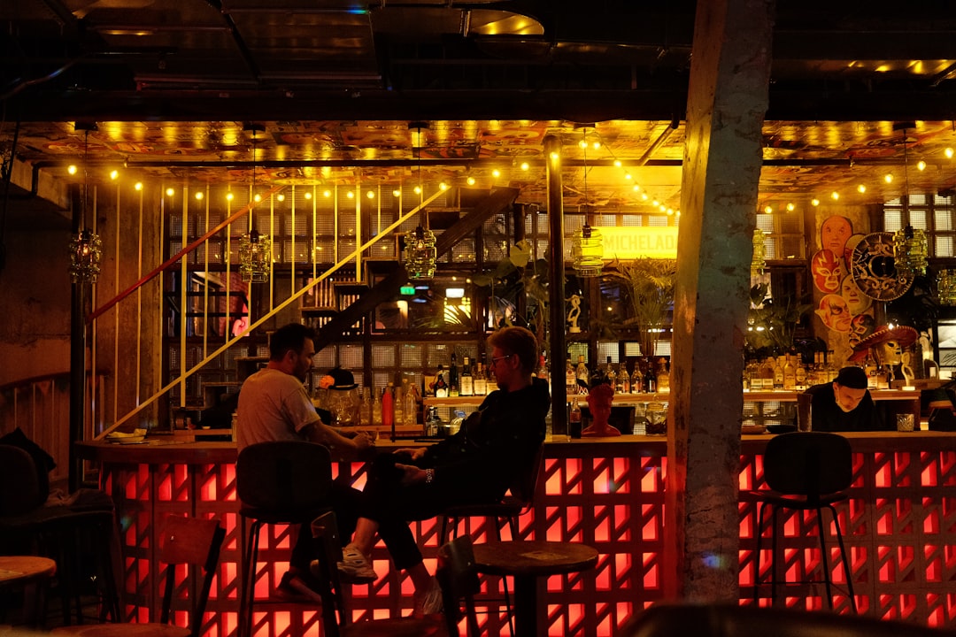 a group of people sitting at a bar,