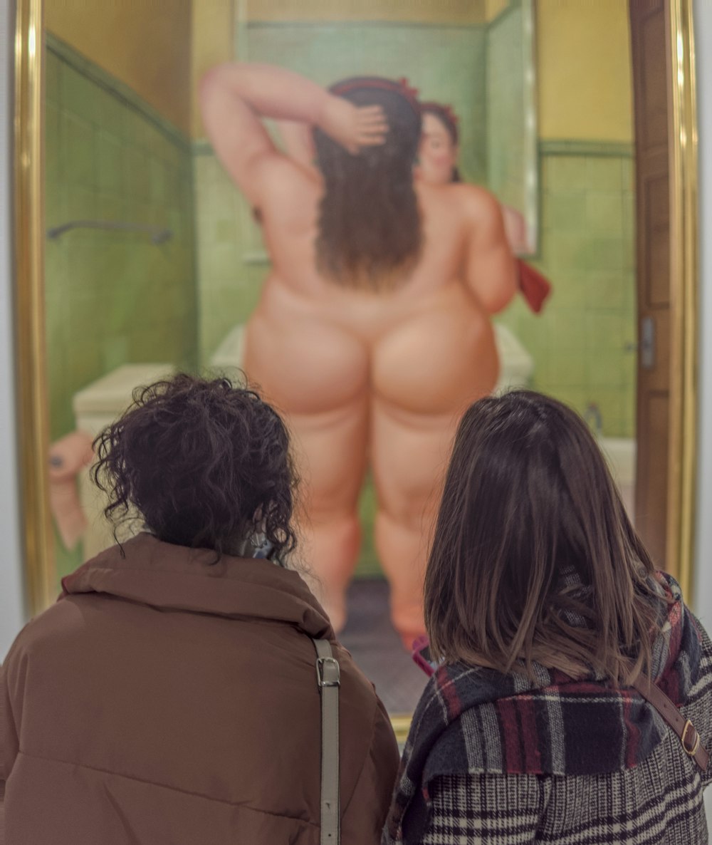 Un par de personas que están mirando una pintura