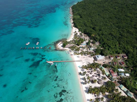 an aerial view of a tropical island with boats