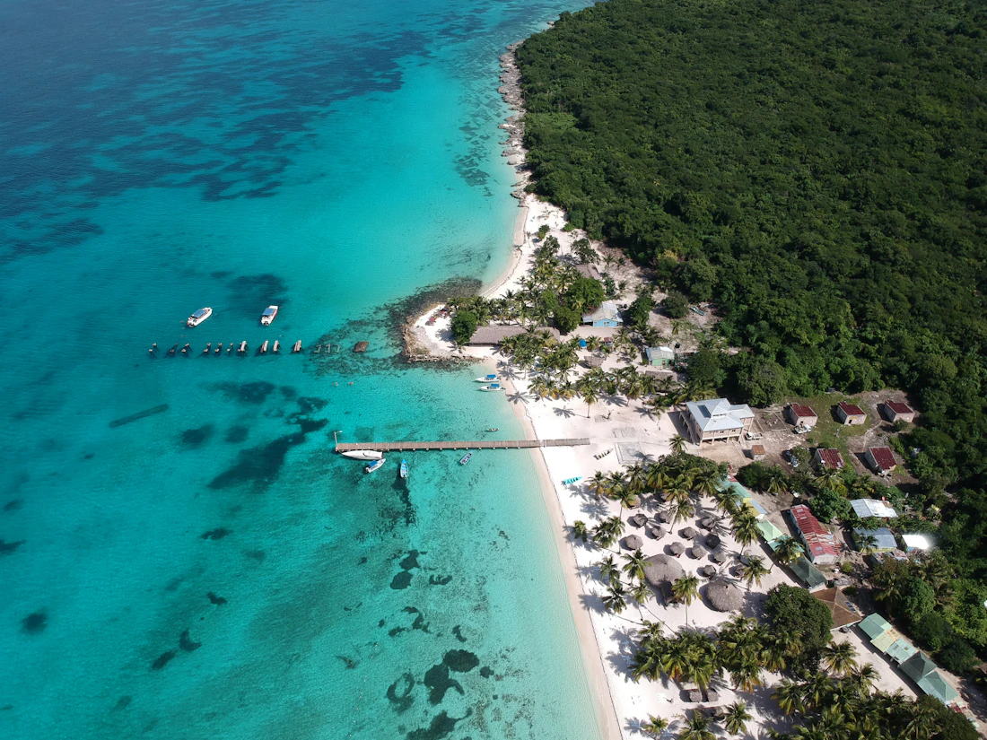 Aerial view of a tropical bay with boats and a white-sand beach