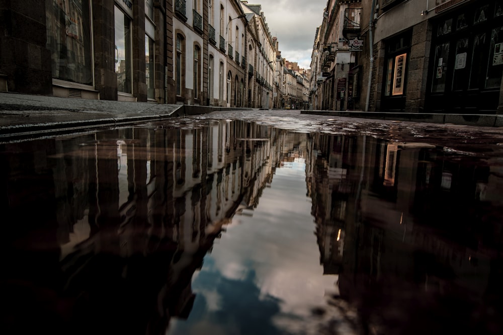 a puddle of water in the middle of a city street