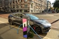 a car plugged into a charging station on a city street