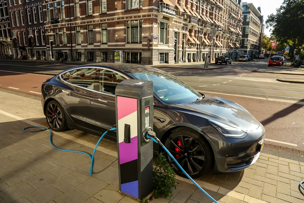 a car plugged into a charging station on a city street