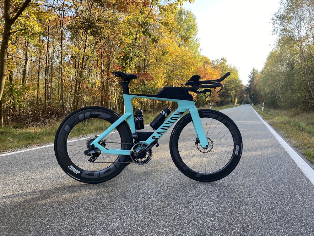 a blue bicycle parked on the side of a road