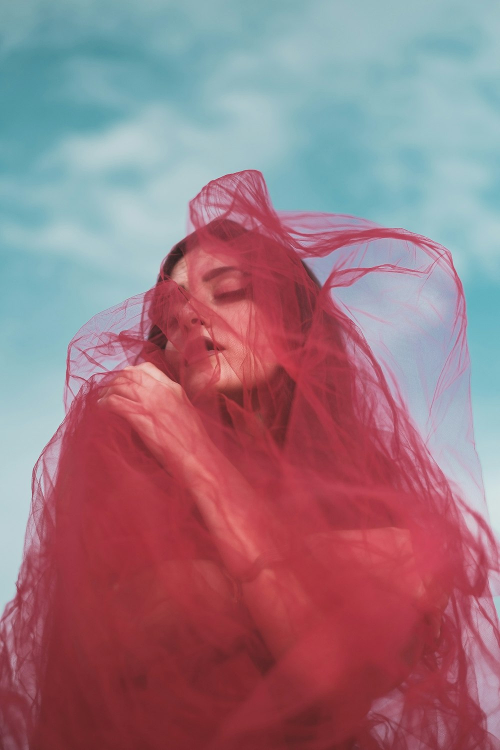 a woman in a red dress with a veil on her head