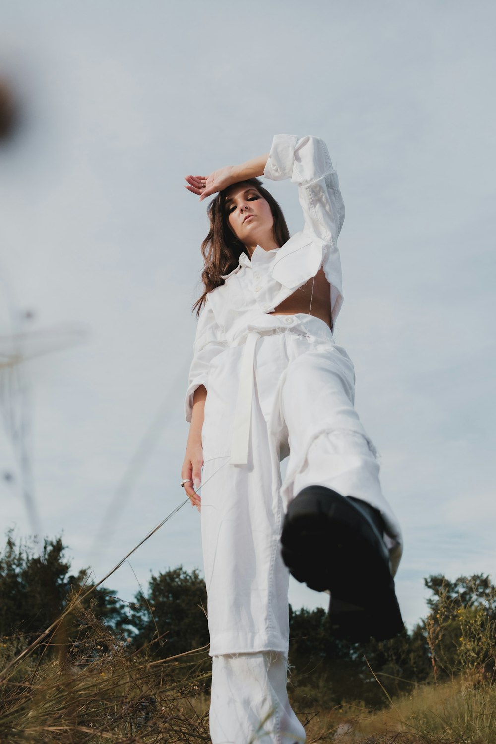 a woman standing in a field with her hands on her head