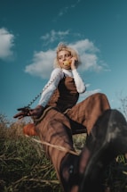 A cheerful camp counselor answering a phone call with a sunny playground in the background.