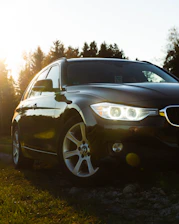 a black car is parked in the grass