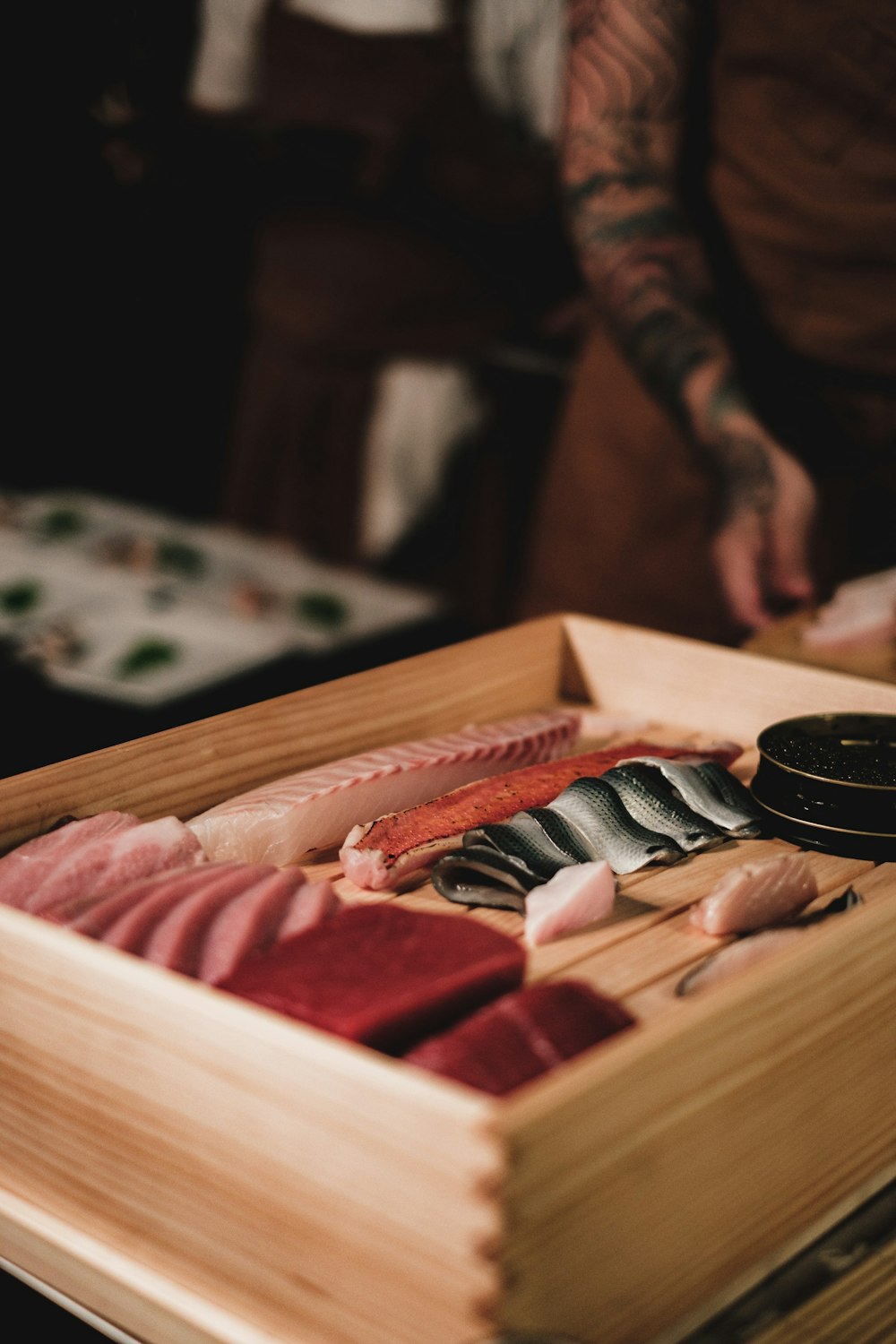 a wooden box filled with different types of sushi
