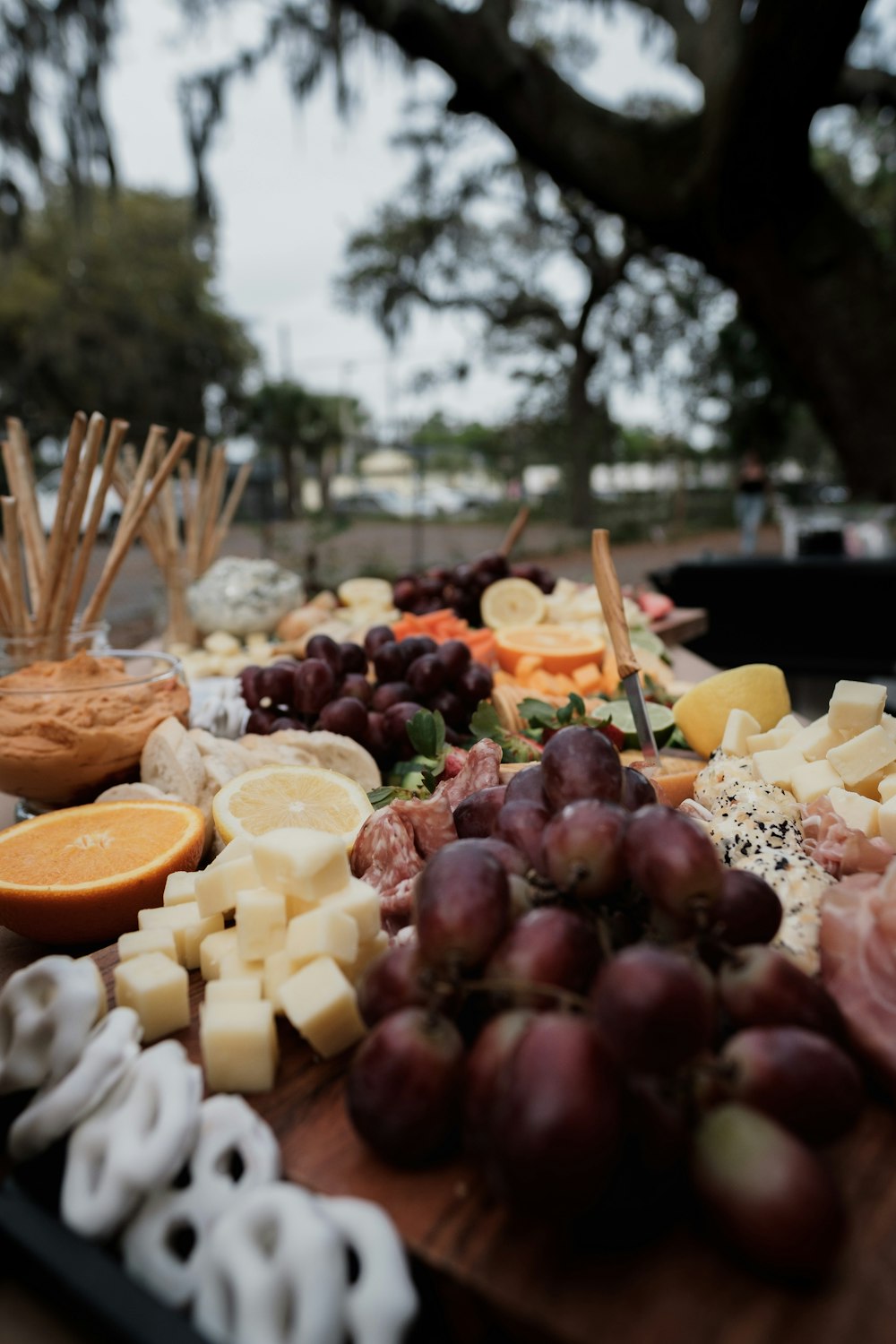 a wooden table topped with lots of cheese and fruit