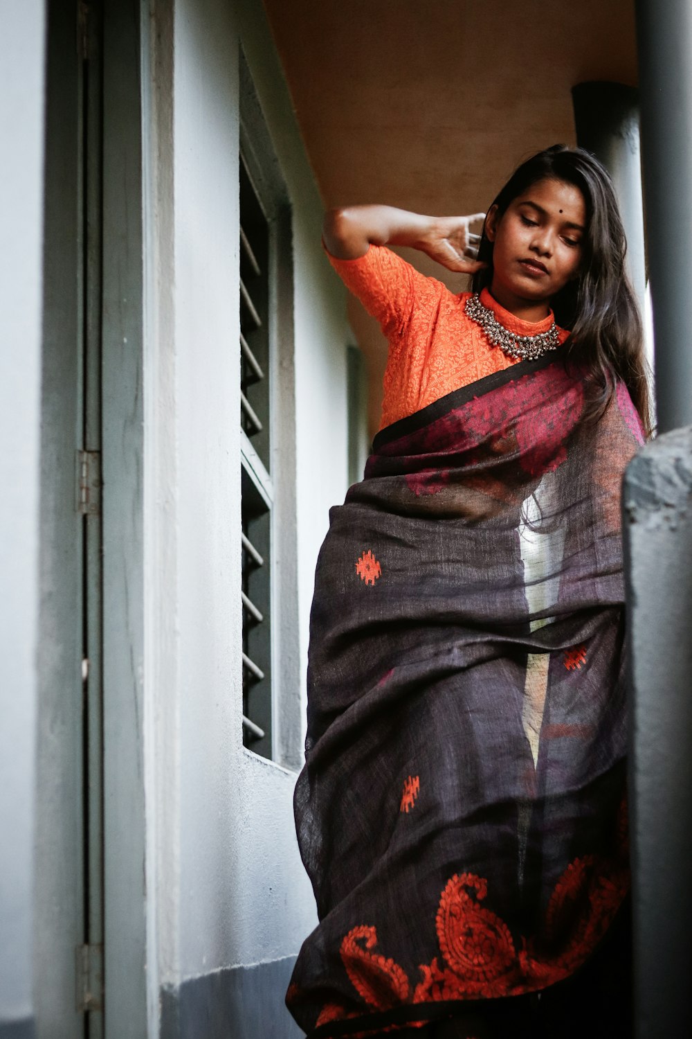 a woman in a sari leaning out of a window