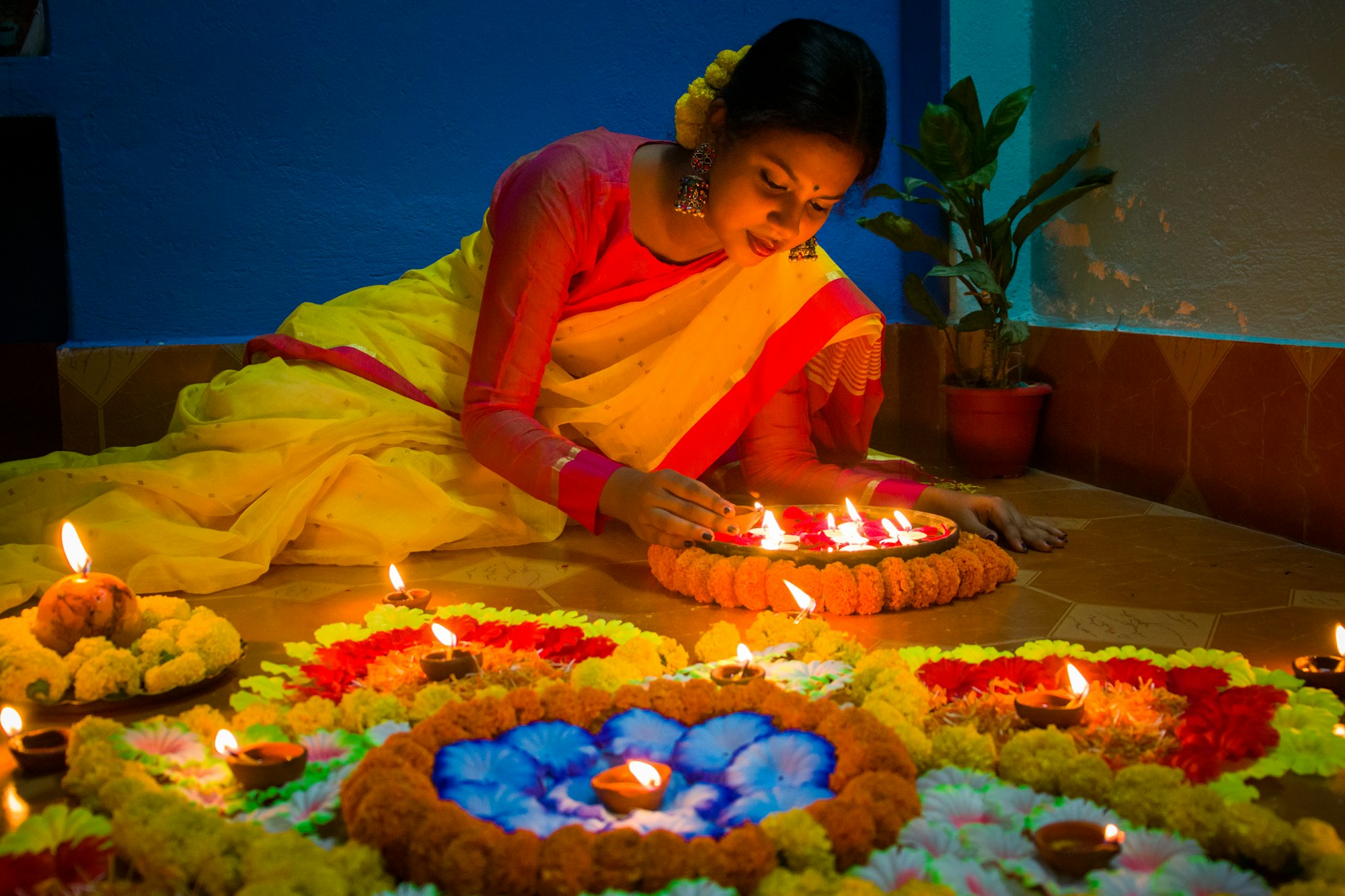 a woman sitting in front of a cake with lit candles