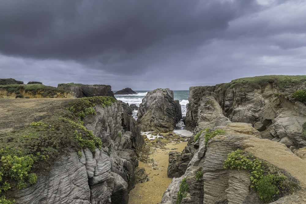 a rocky beach with a body of water in the distance