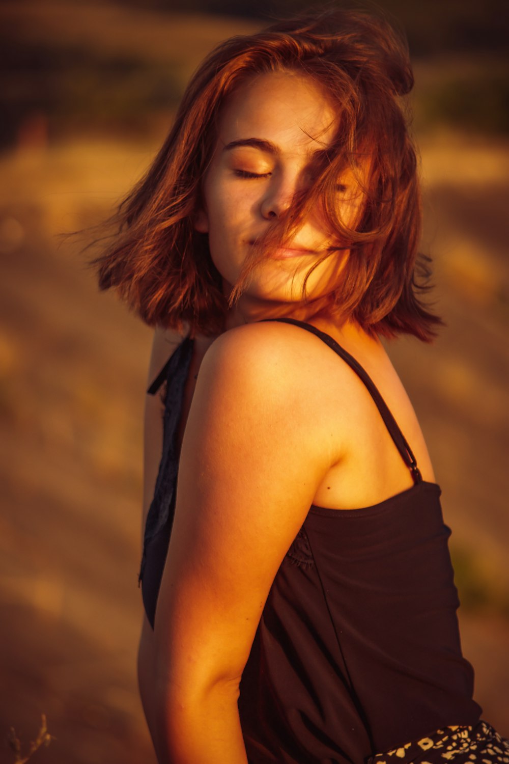 a woman standing in a field with her eyes closed