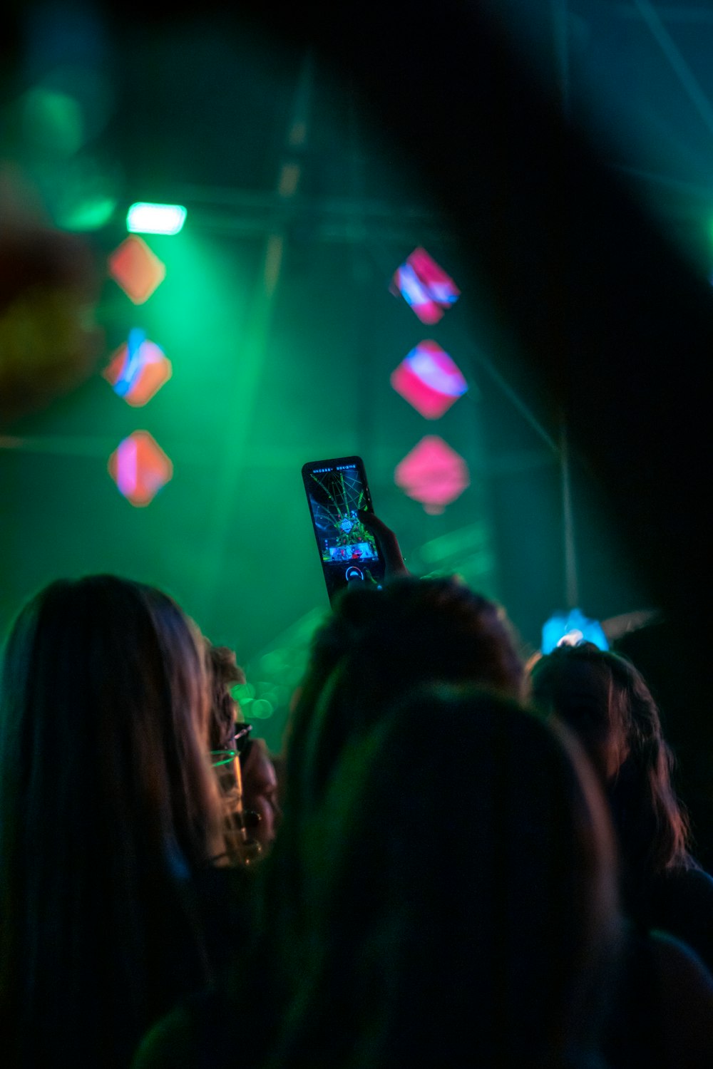 a group of people standing on a stage with a cell phone in their hand