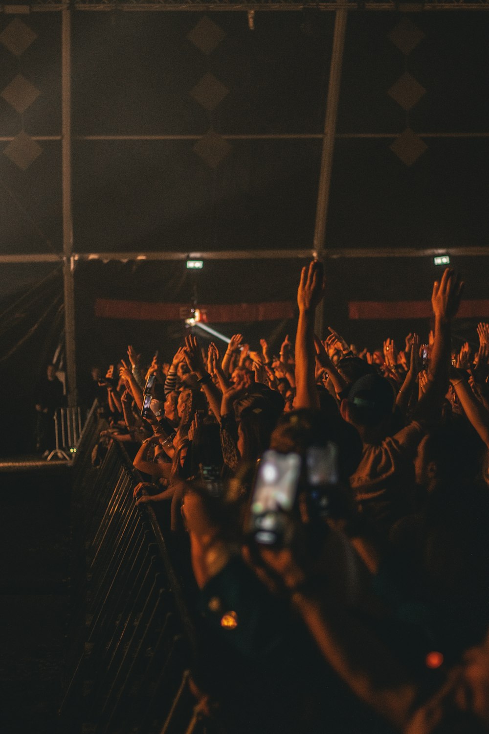 a crowd of people at a concert with their hands in the air