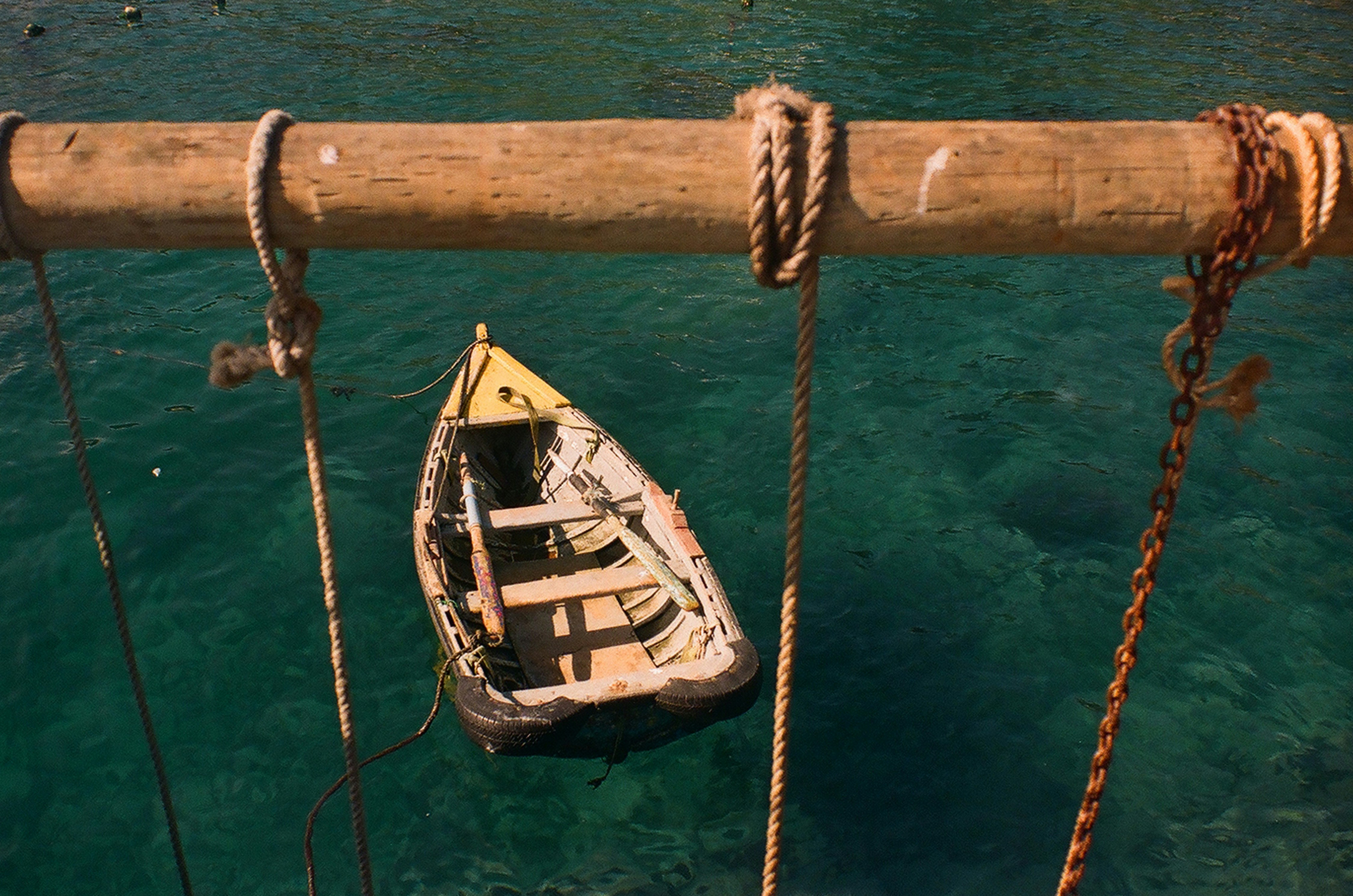 a boat tied to a wooden pole in the water