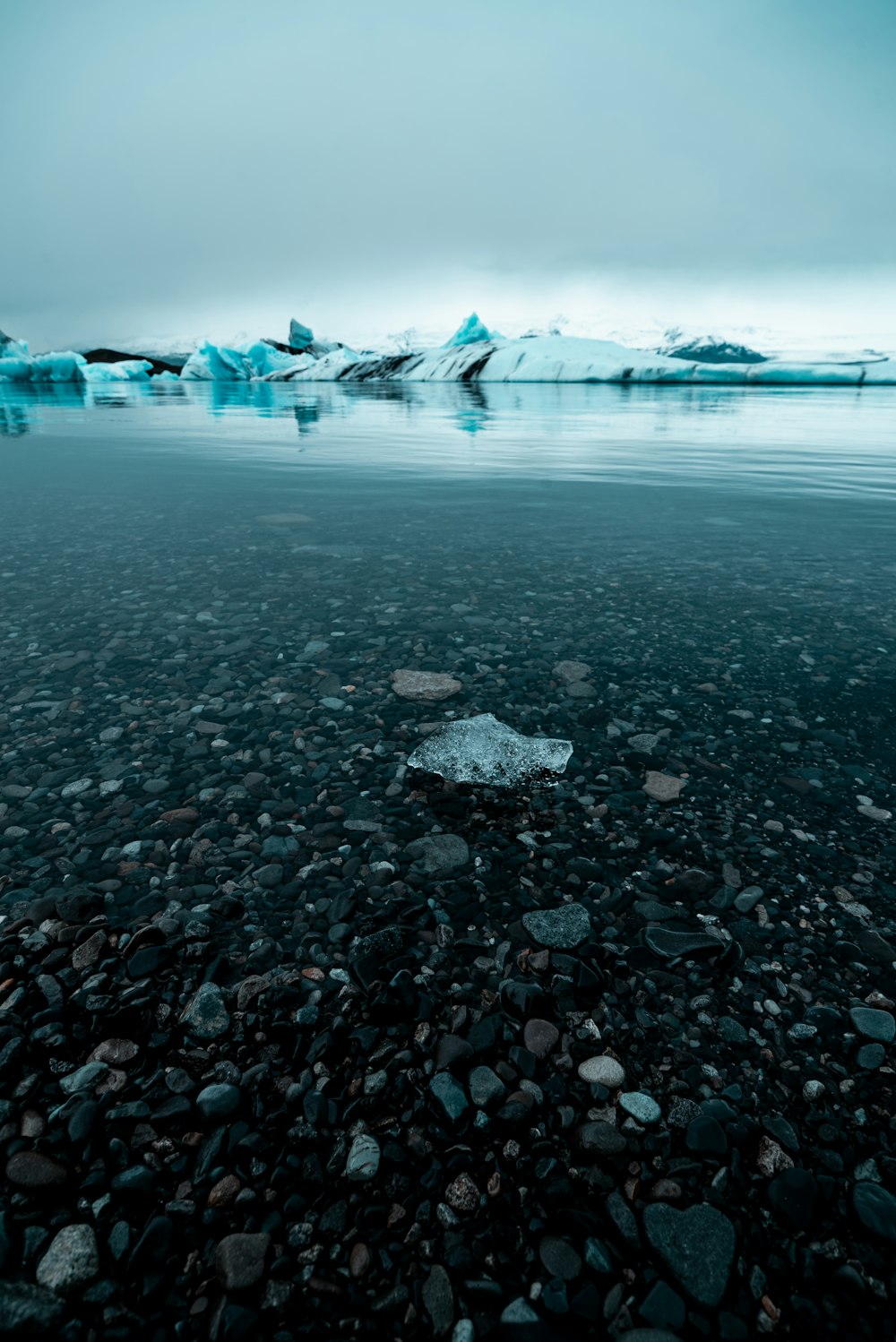 a body of water surrounded by rocks and ice