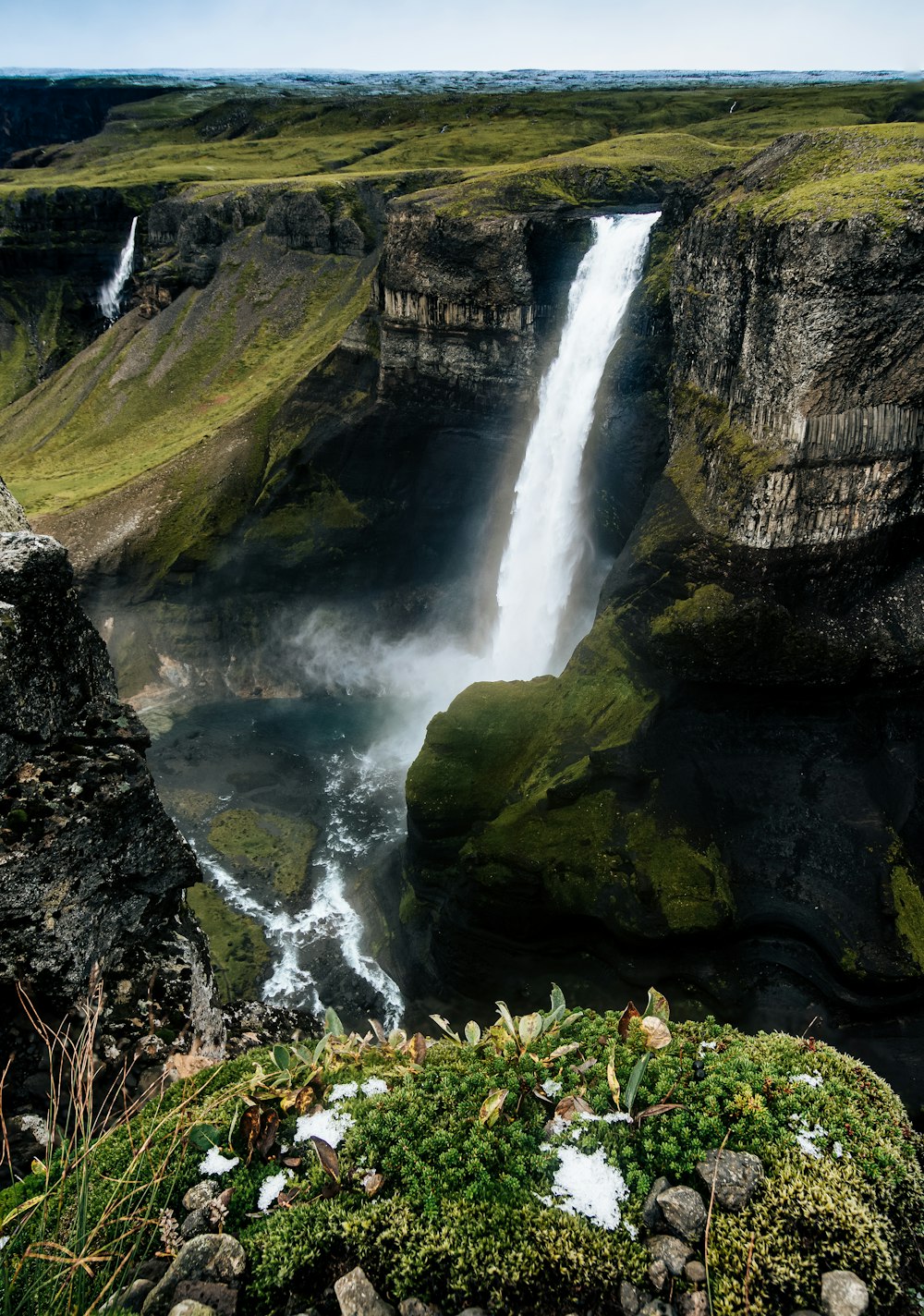 a large waterfall is seen from the top of a cliff