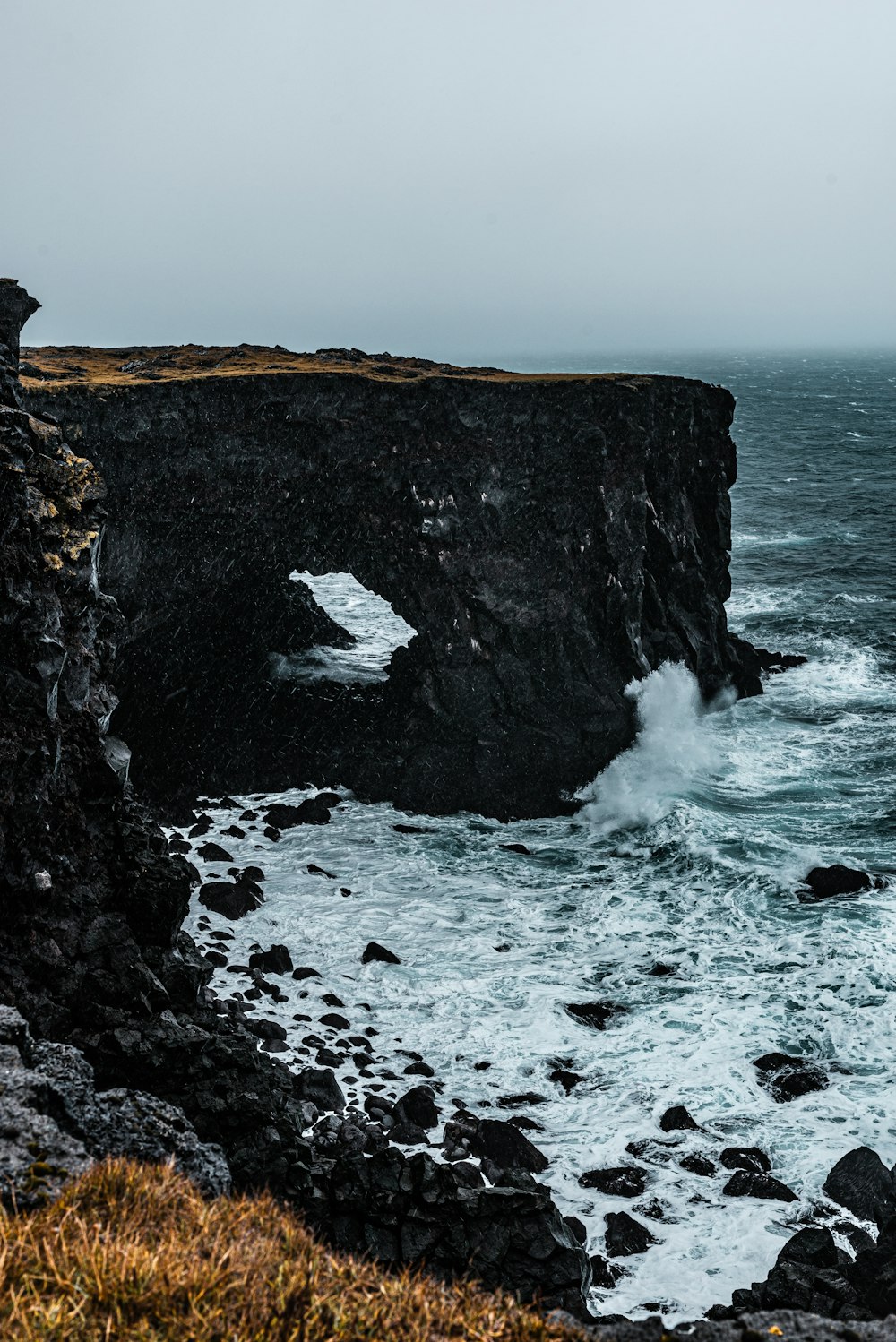 a large body of water near a rocky cliff