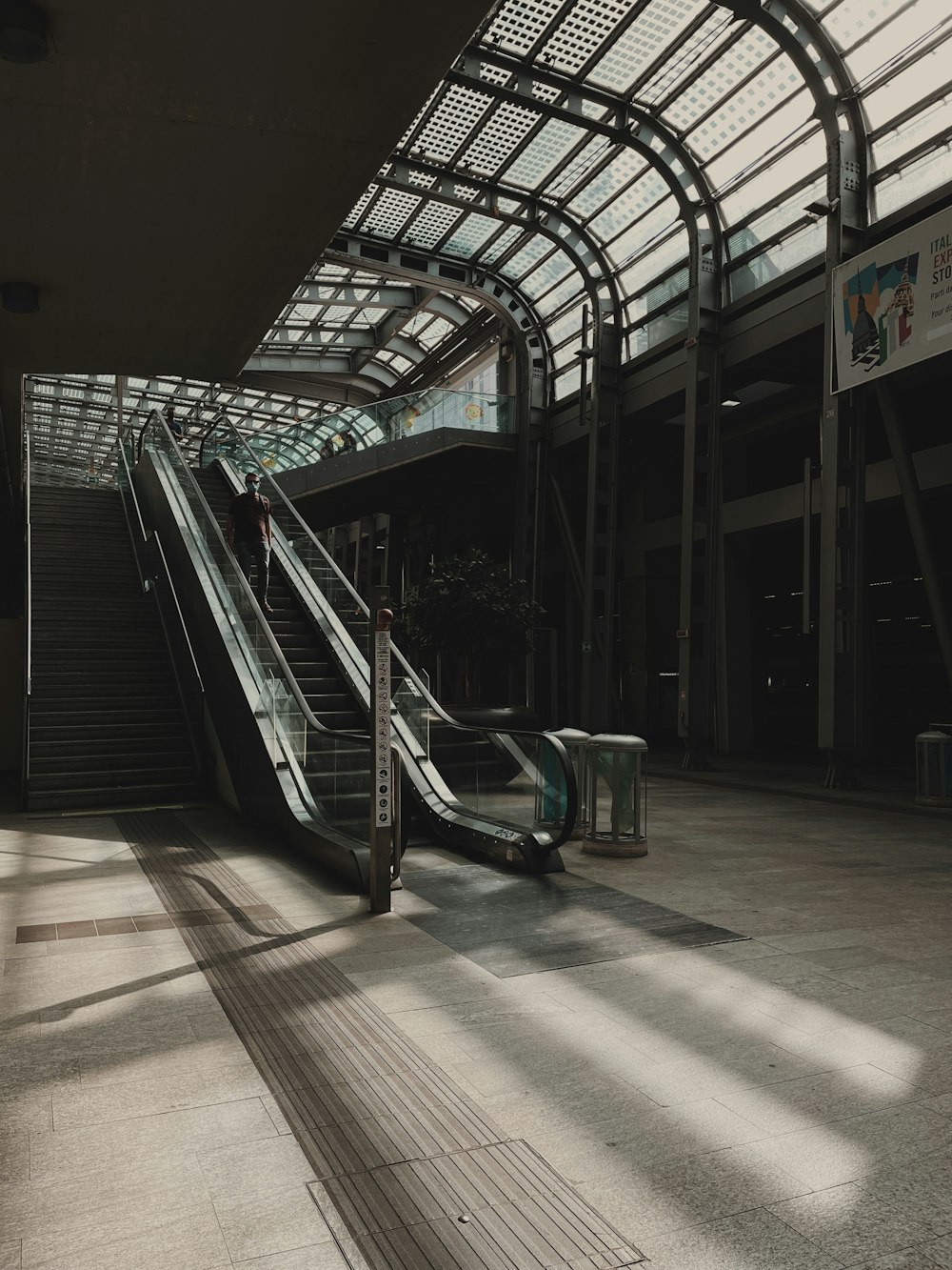 un escalator dans un grand bâtiment avec un puits de lumière