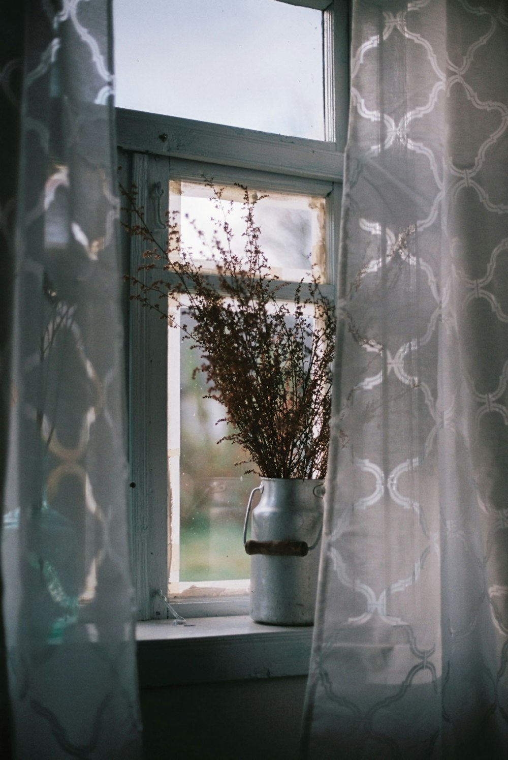 a vase of flowers sitting on a window sill