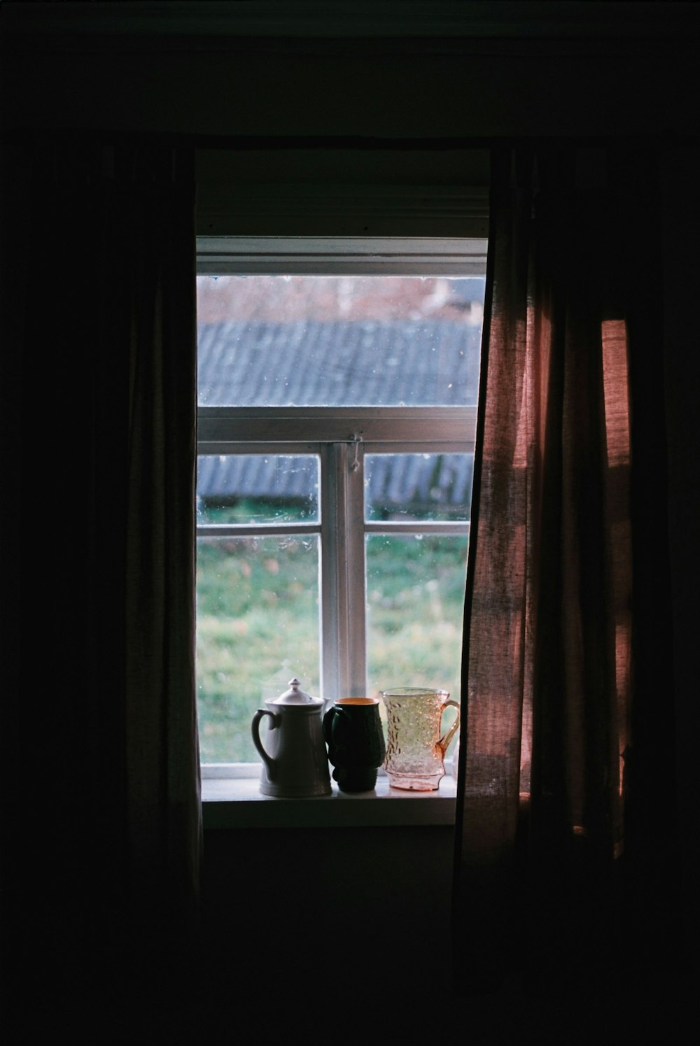 a window sill with two cups on it