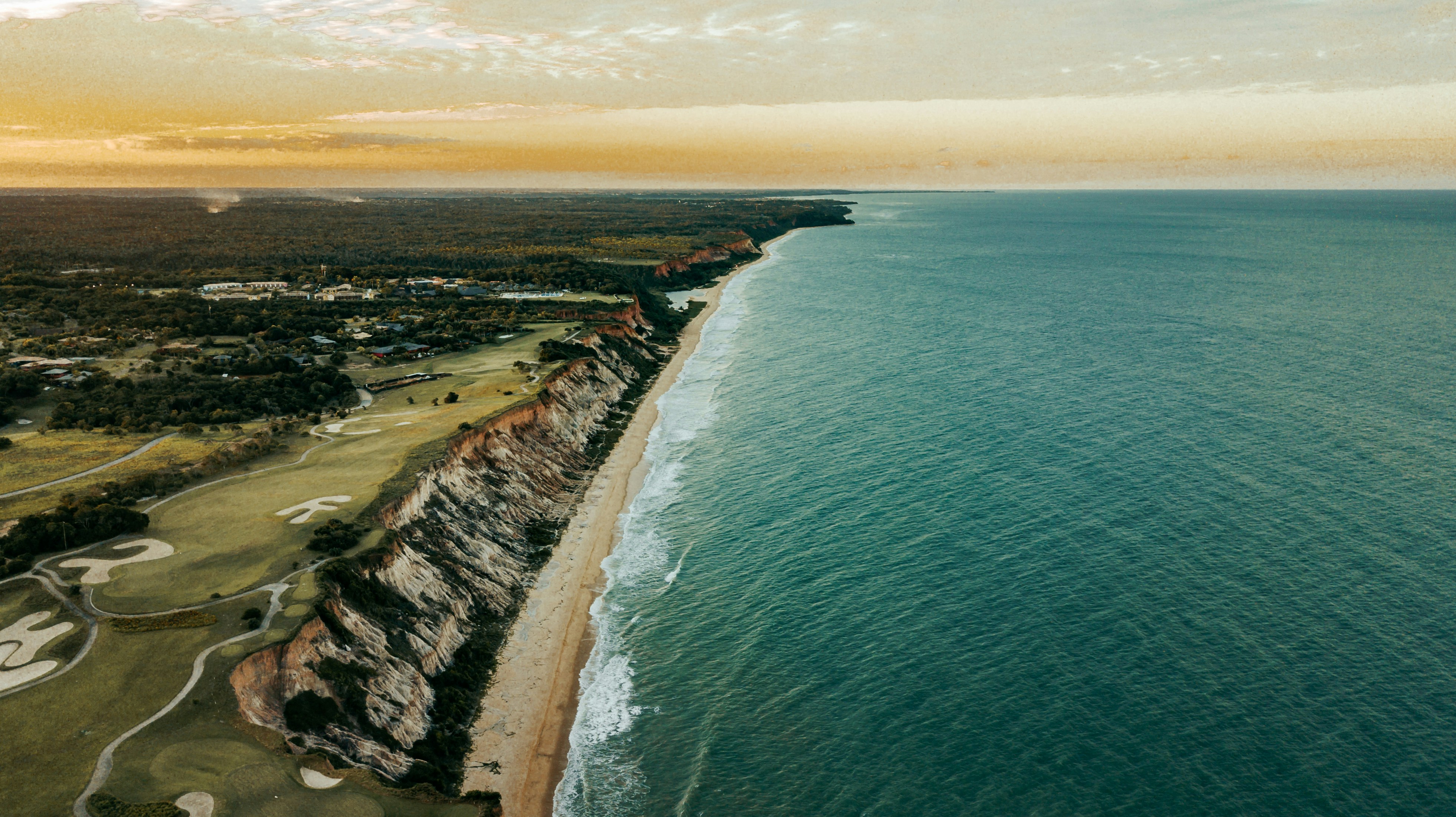 Una vista de una playa junto a un cuerpo de agua
