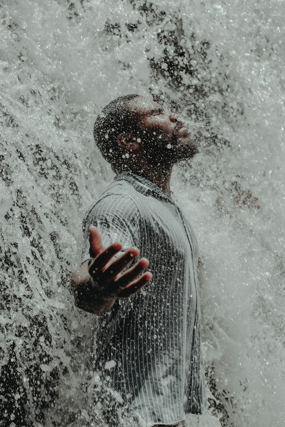 a man is standing in the water with his hands in the air