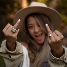 a woman in a hat is making a peace sign
