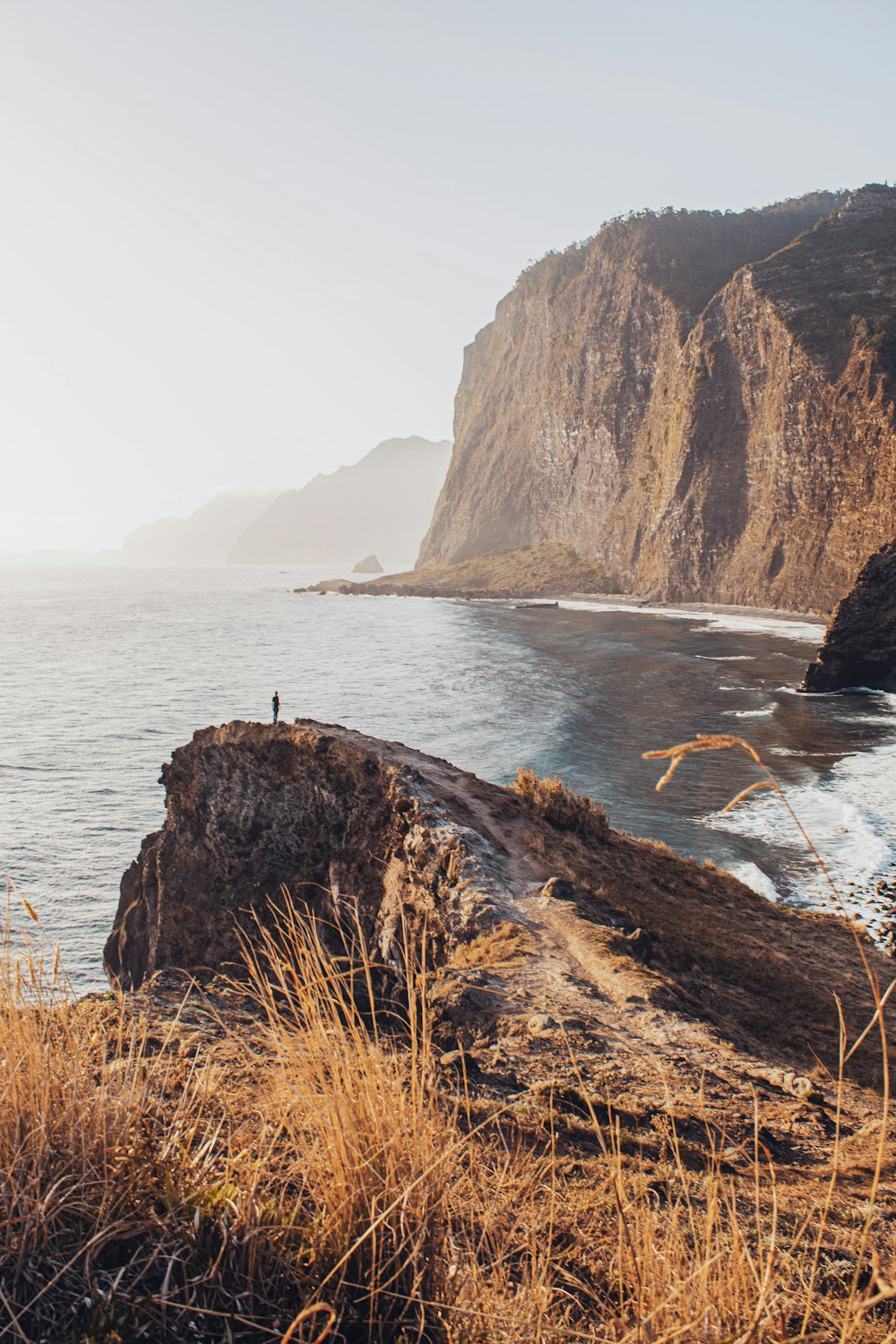 a person standing on a cliff overlooking a body of water