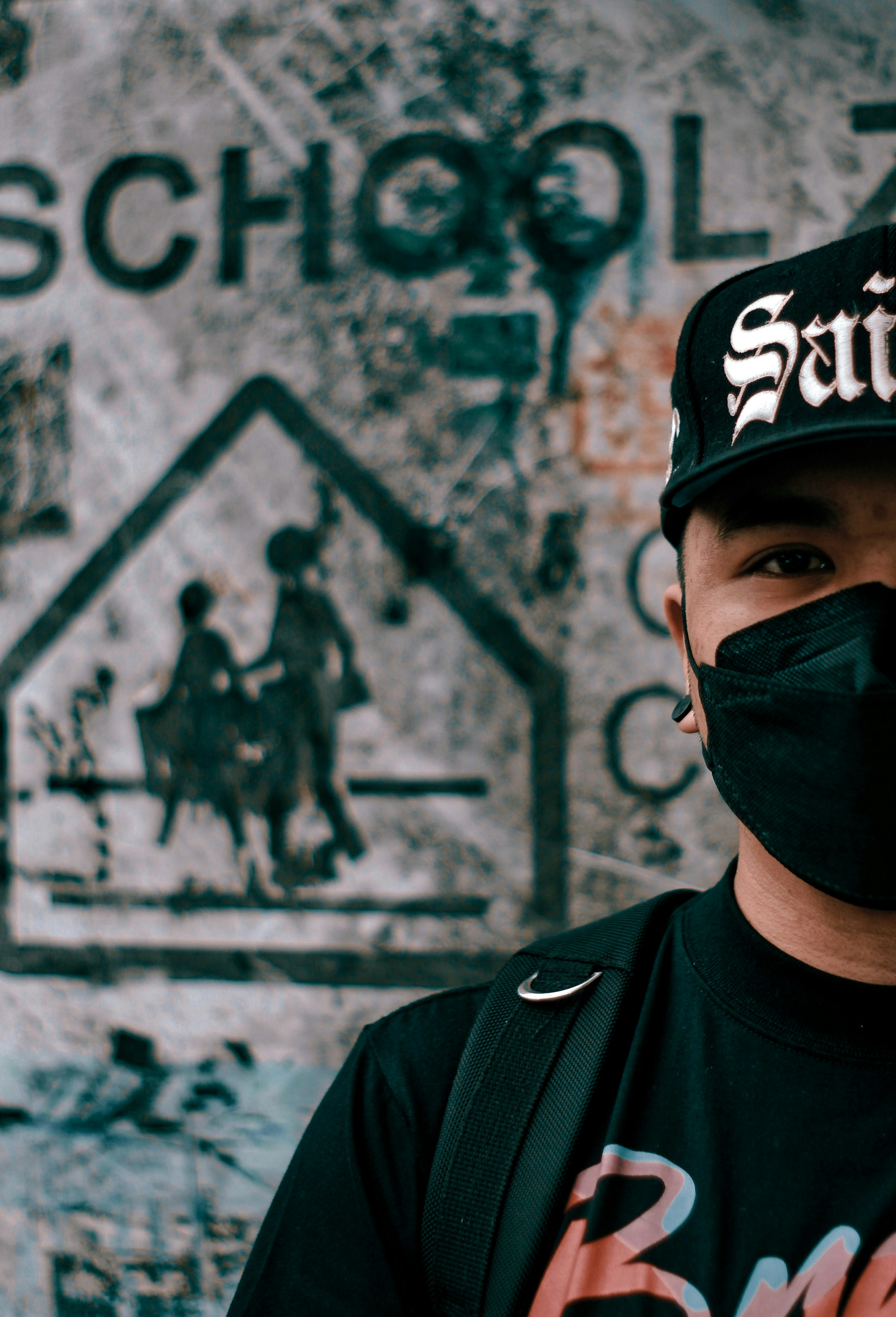 a man wearing a black hat and a black face mask