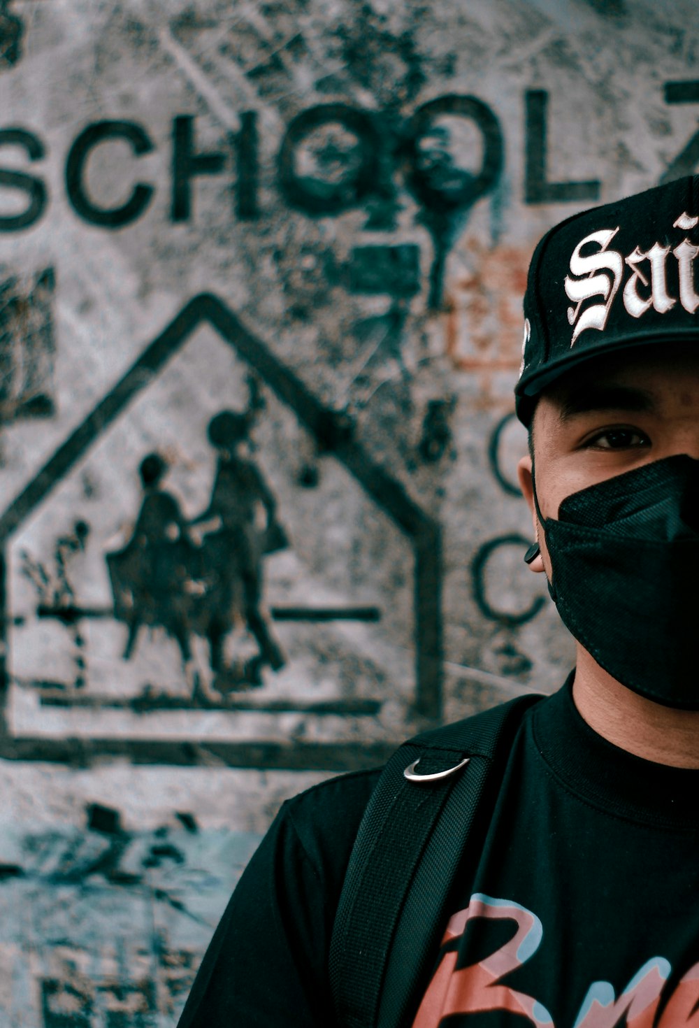 a man wearing a black hat and a black face mask