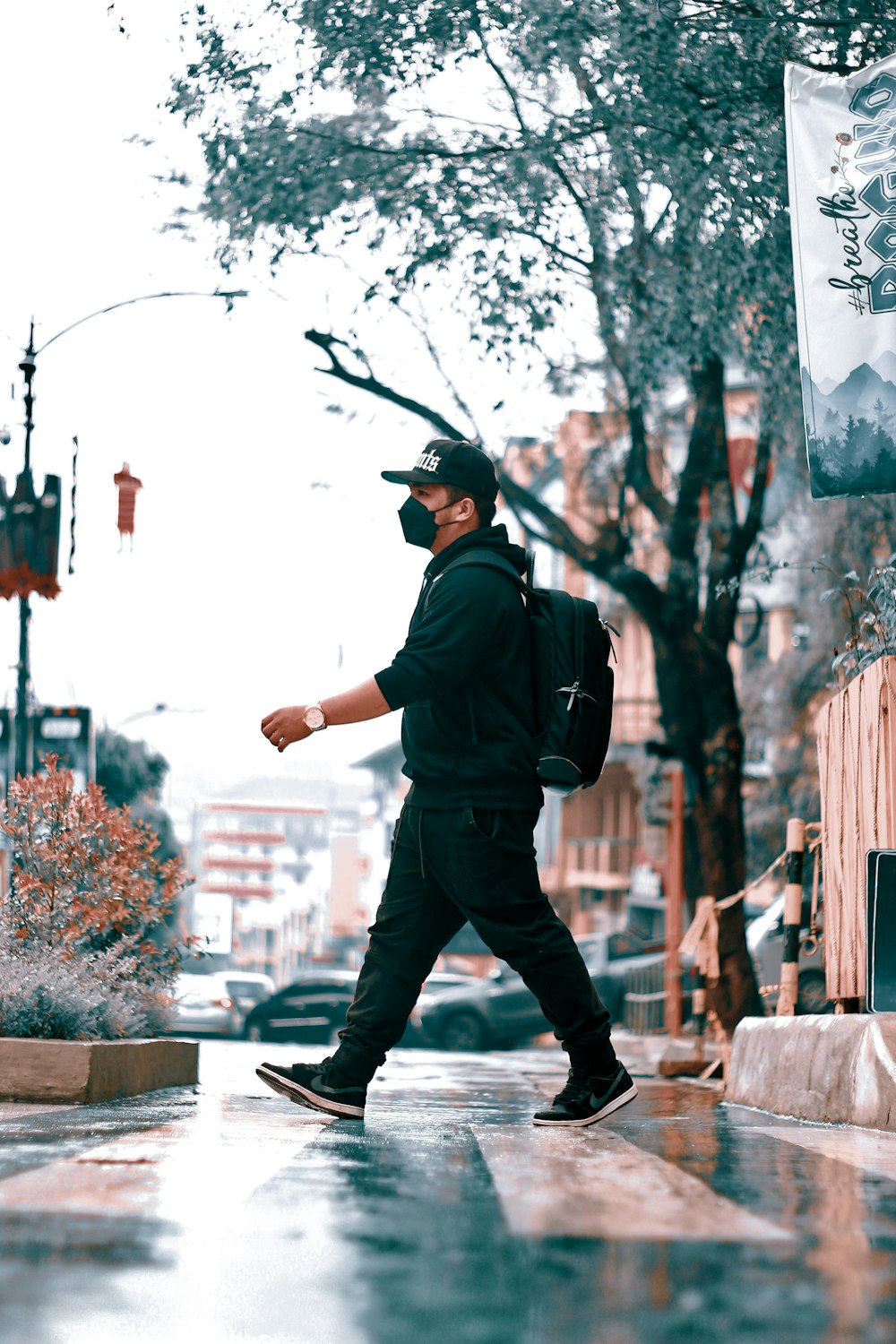 a man walking down a street in the rain