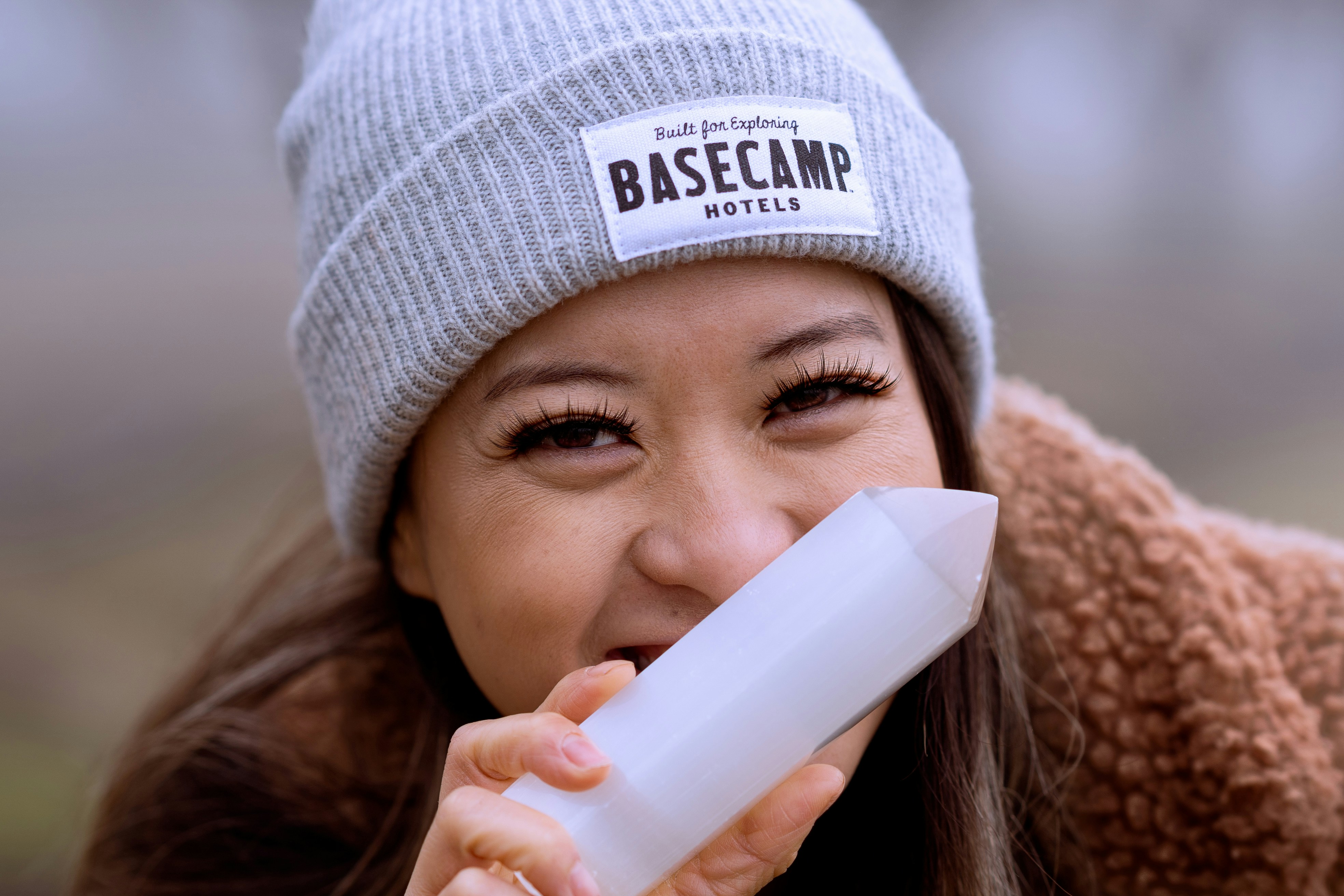 a woman wearing a beanie drinking from a cup