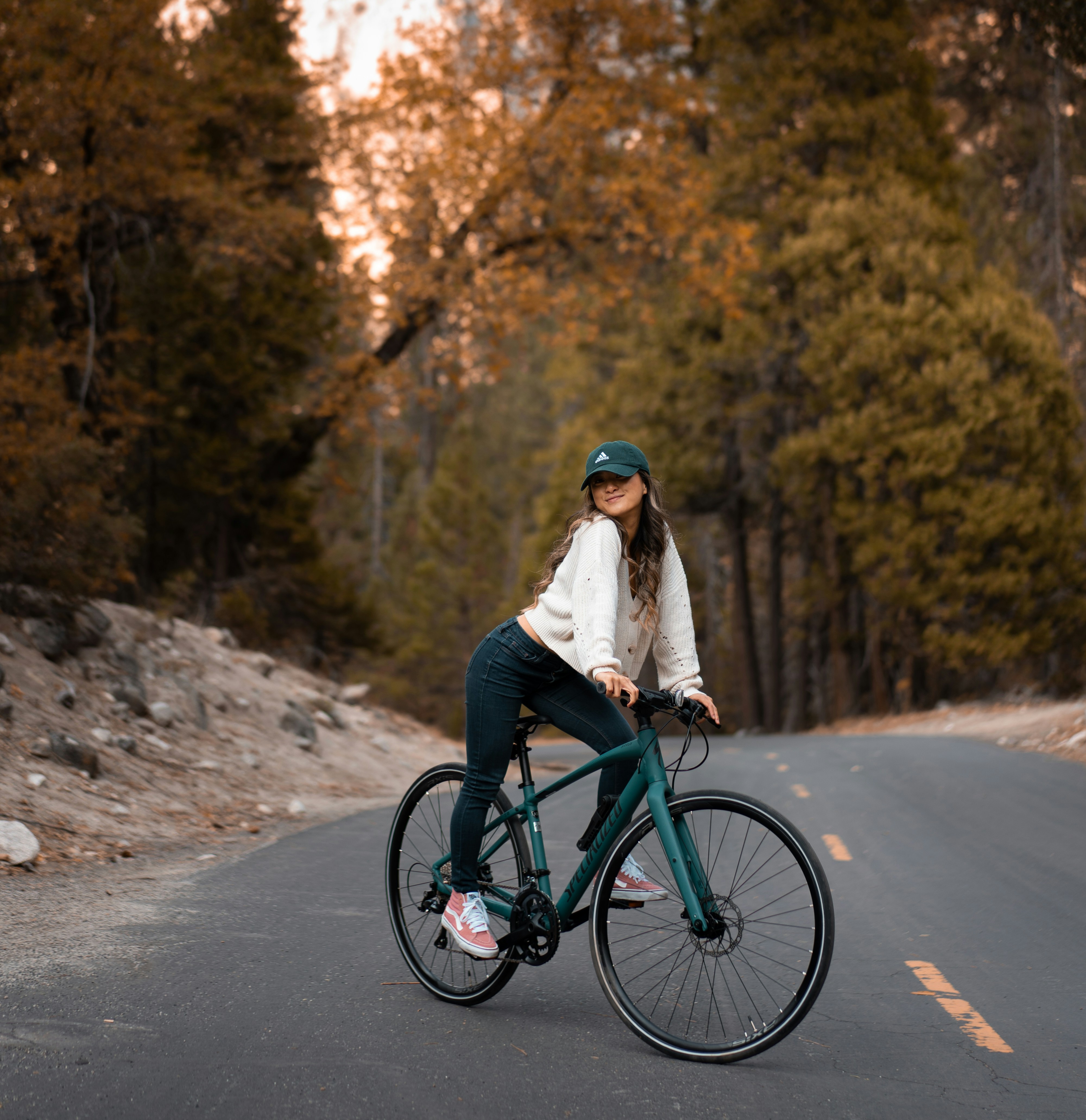 a woman riding a bike down a road