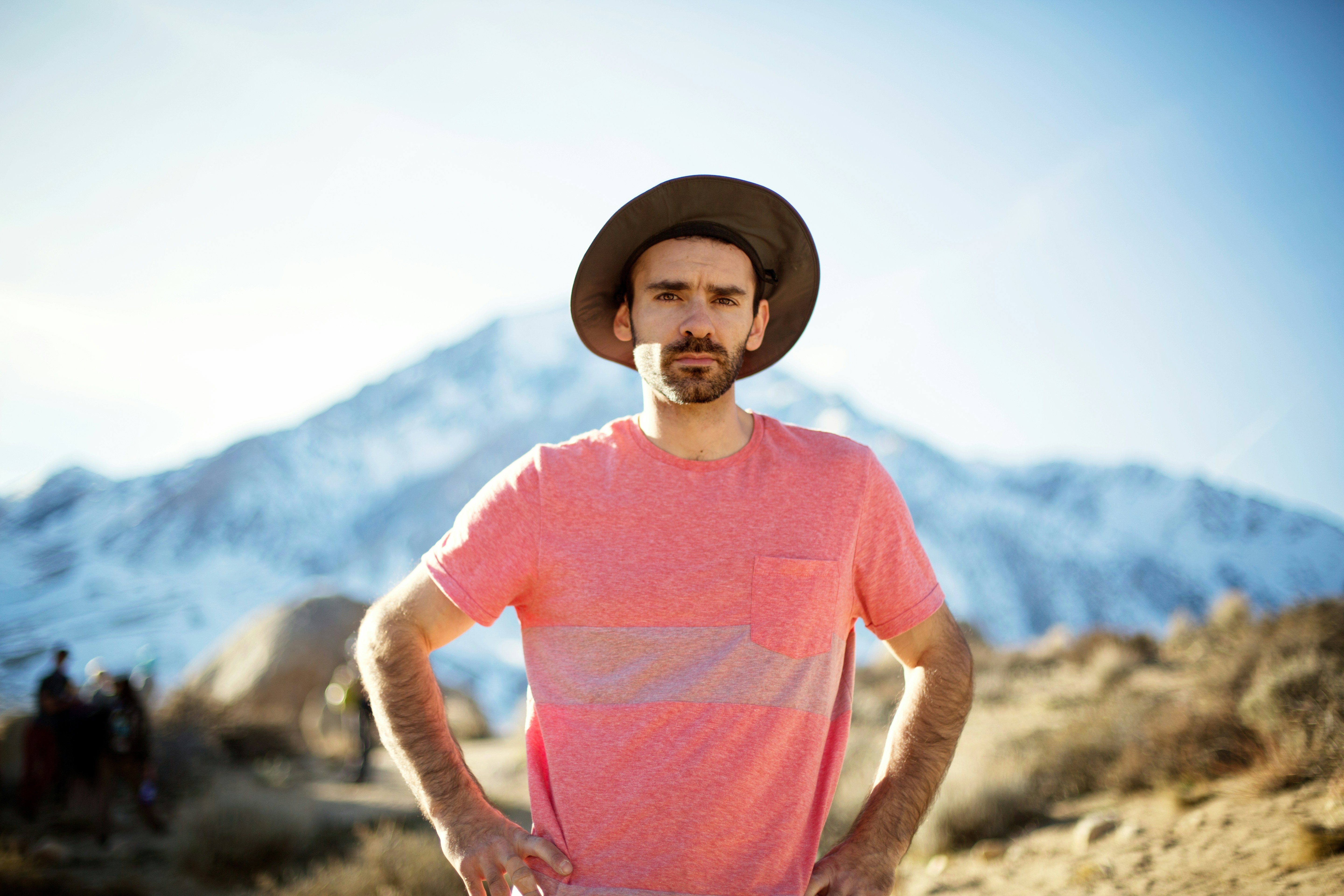 a man wearing a hat standing in the desert