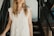 a woman in a white dress is standing on the stairs
